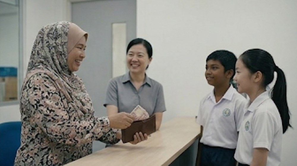 Babak 4: Seorang wanita, pemilik dompet itu, datang ke pejabat dan menerima dompetnya sambil tersenyum kepada murid-murid itu.