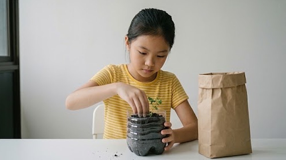 Babak 3: Budak itu menanam anak pokok di dalam botol yang sudah dipotong.